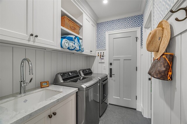 laundry area with ornamental molding, light tile patterned floors, cabinets, sink, and independent washer and dryer