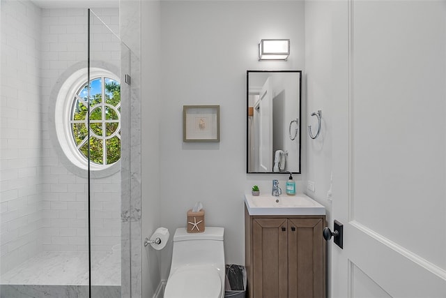 bathroom featuring vanity, toilet, and tiled shower