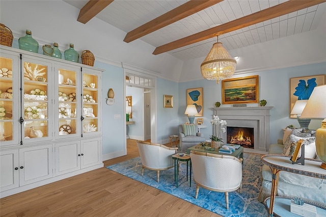 living room with light hardwood / wood-style flooring, vaulted ceiling with beams, and an inviting chandelier