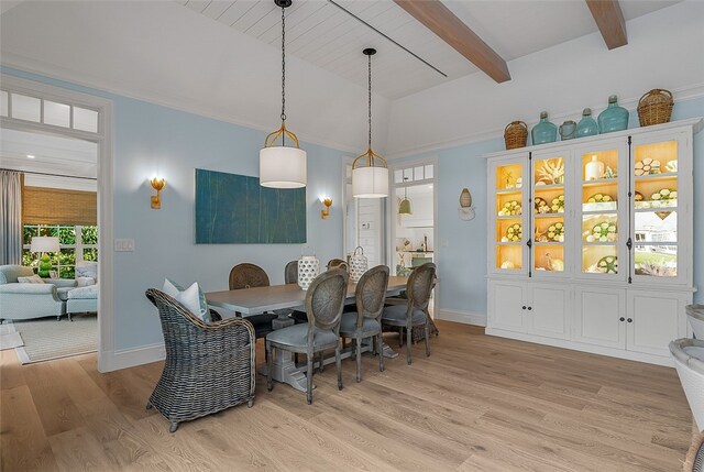 dining room with light hardwood / wood-style flooring and beam ceiling