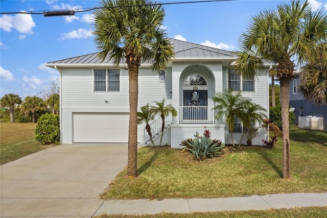 5440 95th St, Sebastian, FL 32958 - view of front of house featuring a standing seam roof, an attached garage, a front yard, and concrete driveway
