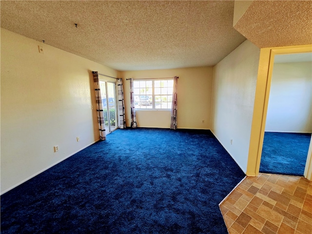 empty room featuring carpet floors and a textured ceiling