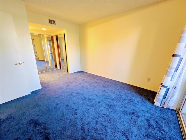 unfurnished room featuring dark colored carpet