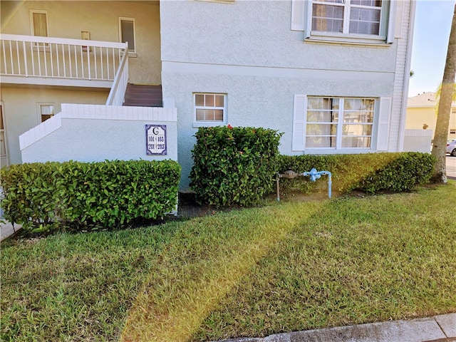 exterior space featuring a lawn and a balcony