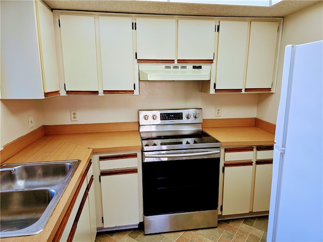 kitchen with white refrigerator, white cabinets, sink, ventilation hood, and electric range