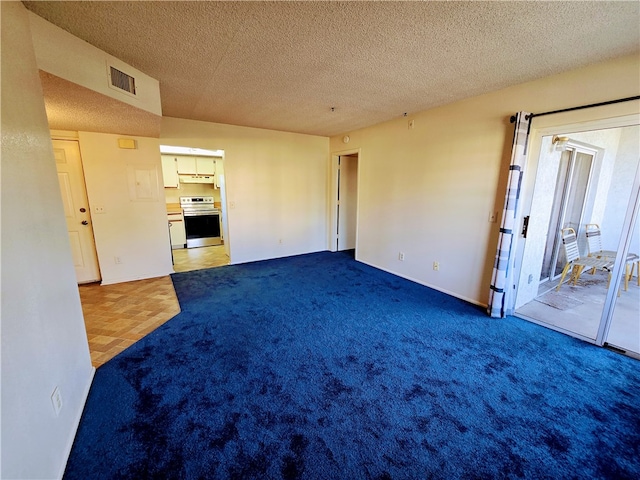 empty room with carpet and a textured ceiling