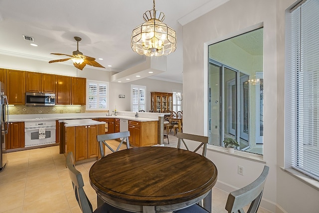 kitchen featuring tasteful backsplash, a kitchen island, appliances with stainless steel finishes, pendant lighting, and kitchen peninsula