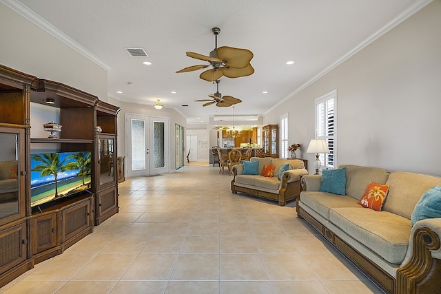 living room featuring french doors, ceiling fan with notable chandelier, light tile patterned floors, and crown molding