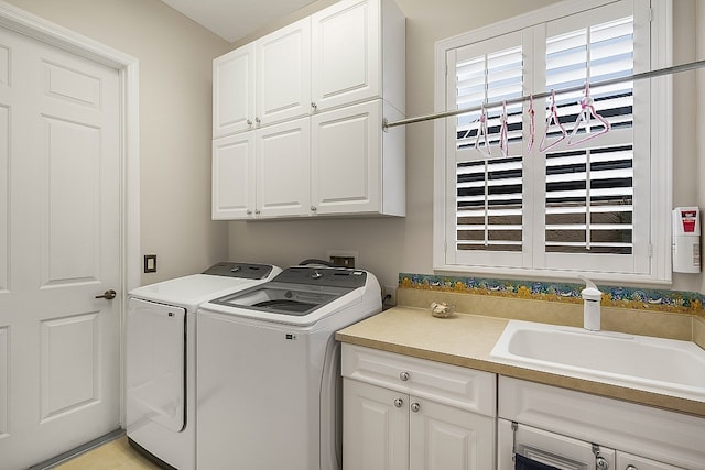 washroom with washing machine and dryer, cabinets, and sink