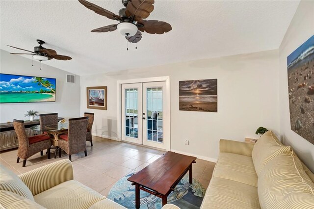 tiled dining space featuring ceiling fan, vaulted ceiling, french doors, and a textured ceiling