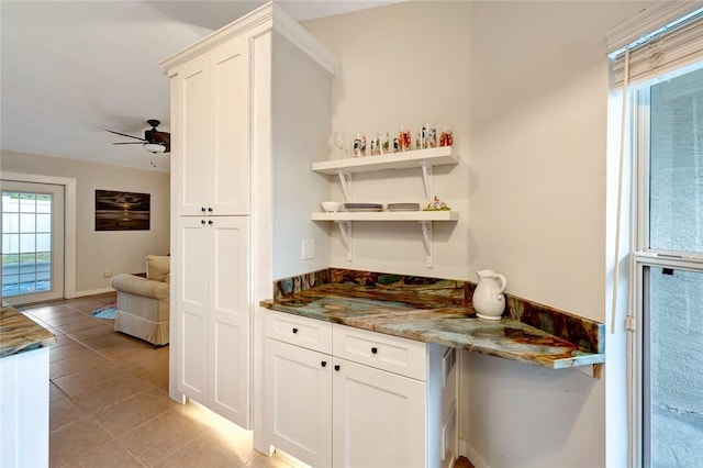 bar featuring white cabinets, ceiling fan, light tile patterned flooring, and stone countertops