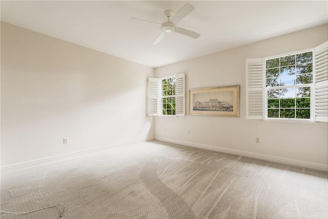 carpeted spare room featuring ceiling fan