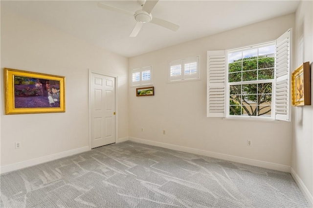 spare room with ceiling fan, a healthy amount of sunlight, and light carpet