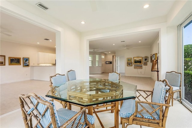 tiled dining space with crown molding and ceiling fan