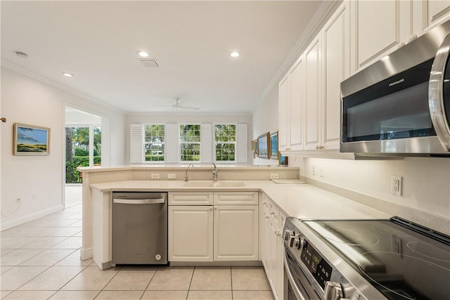 kitchen with light tile patterned flooring, sink, ornamental molding, kitchen peninsula, and stainless steel appliances