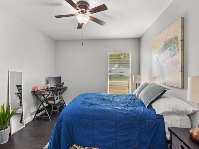 bedroom featuring baseboards, a textured ceiling, wood finished floors, and a ceiling fan