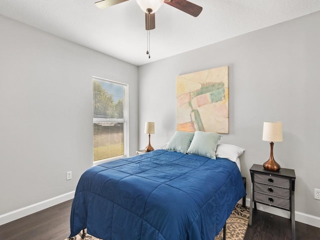 bedroom with ceiling fan, baseboards, and wood finished floors