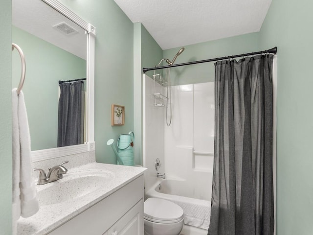 bathroom with vanity, toilet, visible vents, and a textured ceiling