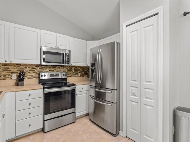 kitchen featuring backsplash, white cabinetry, appliances with stainless steel finishes, light countertops, and vaulted ceiling