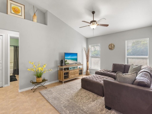 tiled living area with ceiling fan, baseboards, and vaulted ceiling