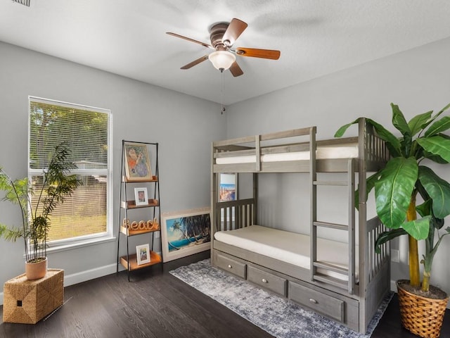 bedroom featuring visible vents, baseboards, dark wood-type flooring, and a ceiling fan