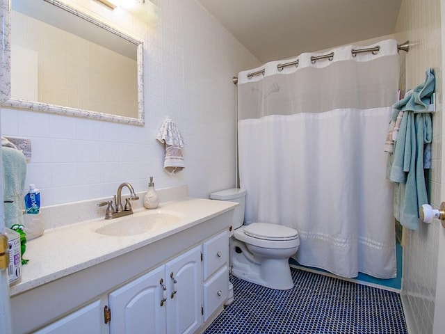 full bath featuring toilet, vanity, tile patterned flooring, and tile walls