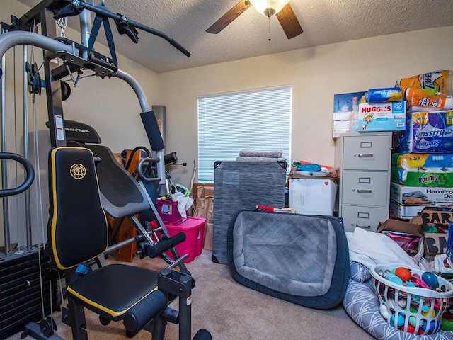 workout room featuring a textured ceiling, carpet flooring, and ceiling fan