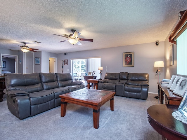 carpeted living room with a textured ceiling, ceiling fan, and visible vents
