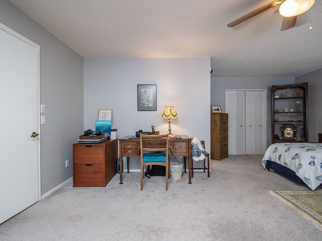 carpeted bedroom with a closet, ceiling fan, and a textured ceiling