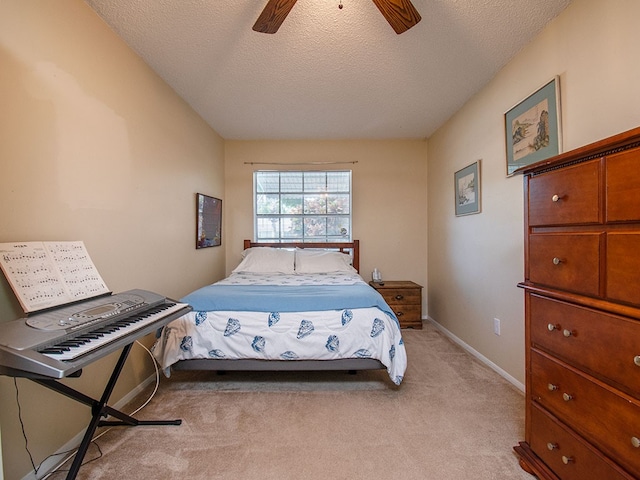bedroom featuring baseboards, a textured ceiling, ceiling fan, and light colored carpet