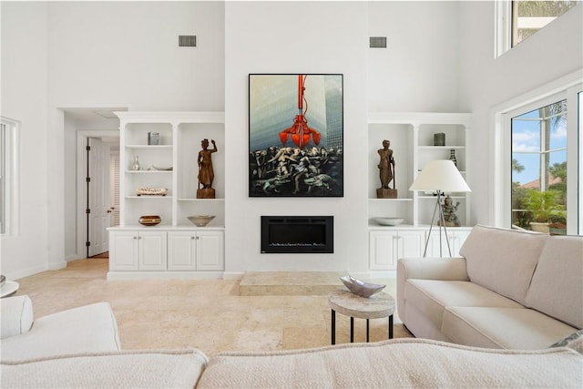 living room featuring a high ceiling, light carpet, and built in features