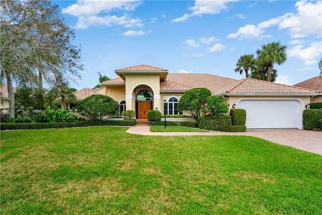 mediterranean / spanish-style home featuring a garage and a front yard