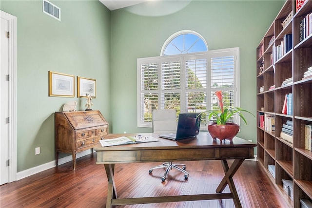 home office with dark hardwood / wood-style flooring