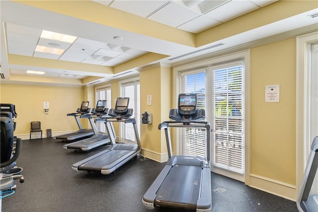 gym with a tray ceiling and a drop ceiling