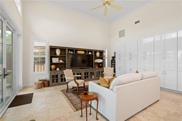 living room featuring crown molding, a towering ceiling, and ceiling fan