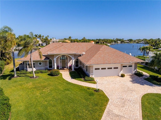 single story home with a garage, a water view, and a front yard