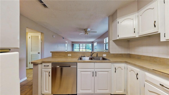 kitchen featuring sink, ceiling fan, white cabinets, stainless steel dishwasher, and kitchen peninsula