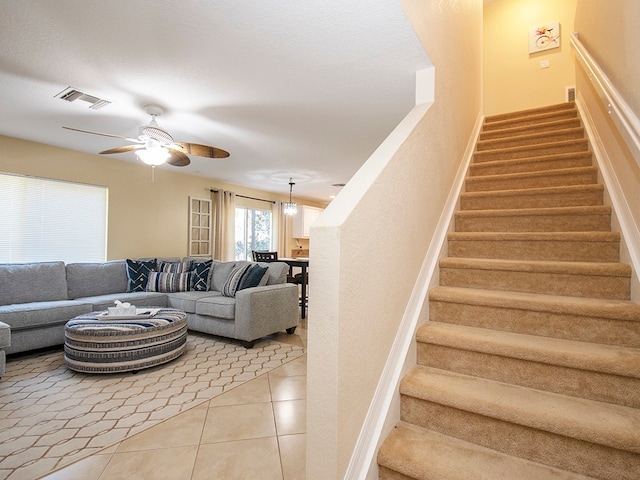 stairs with tile patterned flooring and ceiling fan