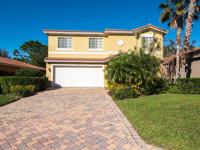 mediterranean / spanish house featuring a garage and a front yard