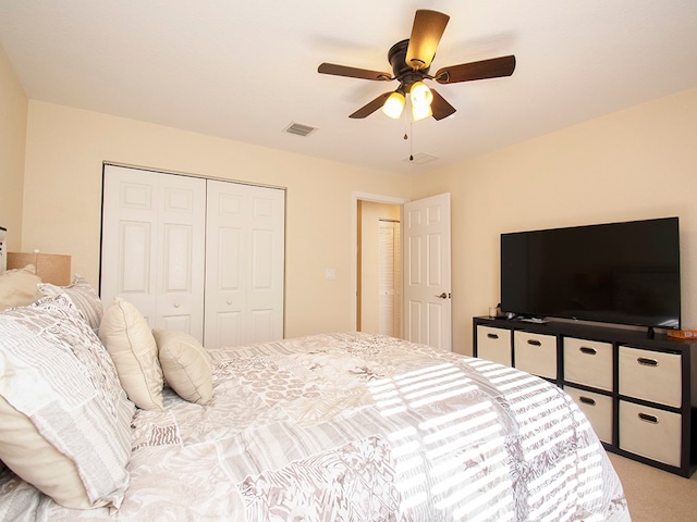 carpeted bedroom featuring ceiling fan and a closet