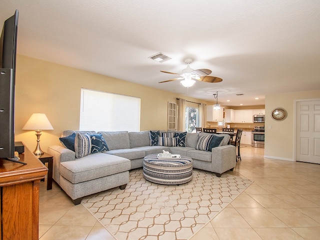 living room featuring light tile patterned flooring and ceiling fan