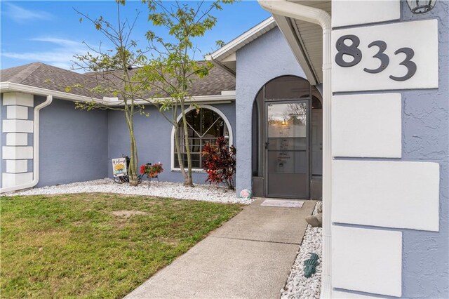 ranch-style home featuring a front yard, concrete driveway, an attached garage, and stucco siding