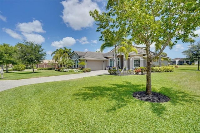 ranch-style home with a front yard, driveway, a garage, and stucco siding