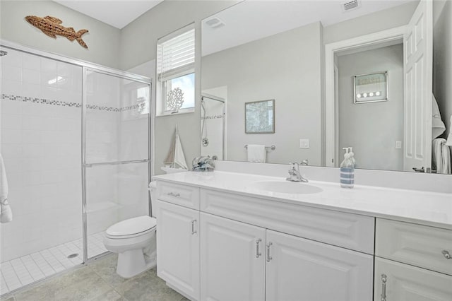bathroom with visible vents, a shower stall, toilet, and vanity