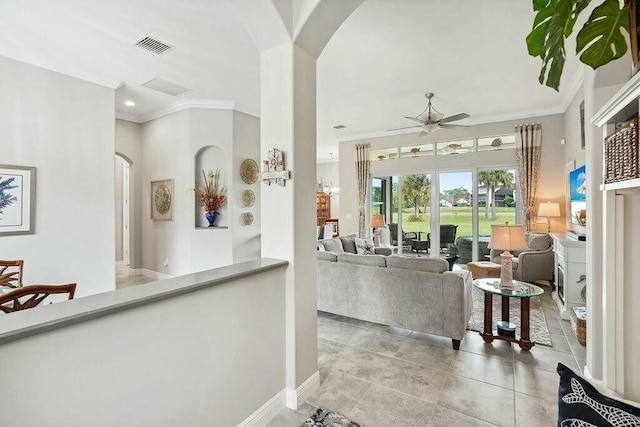 living area featuring ceiling fan, arched walkways, and crown molding