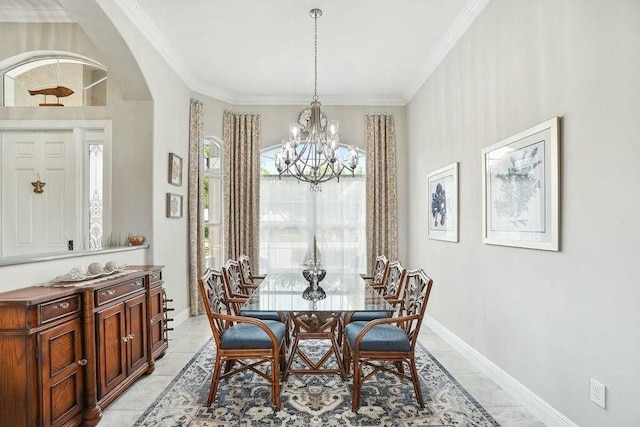 dining area with arched walkways, light tile patterned floors, a notable chandelier, baseboards, and crown molding