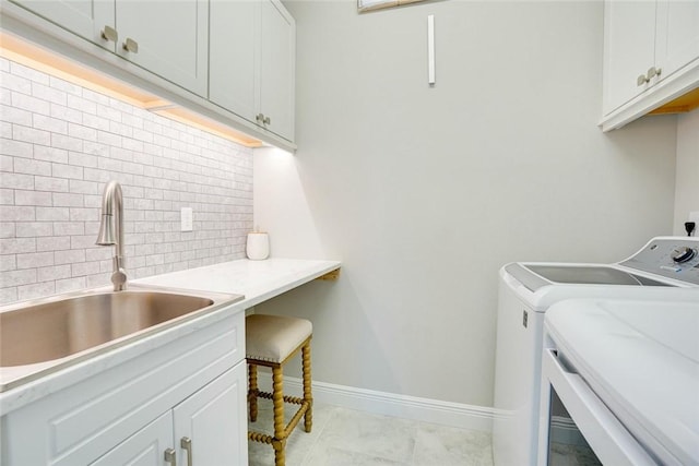 washroom with separate washer and dryer, cabinet space, baseboards, and a sink