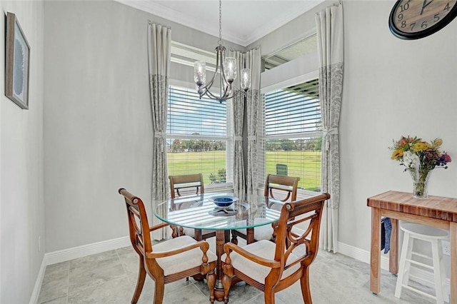 dining space with baseboards, ornamental molding, and a notable chandelier