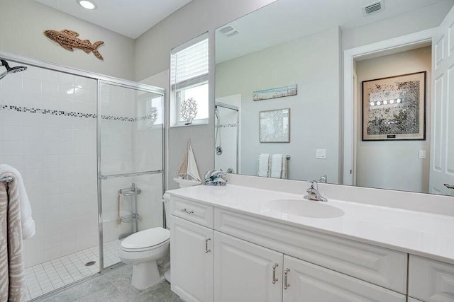 full bathroom featuring a stall shower, visible vents, vanity, and toilet