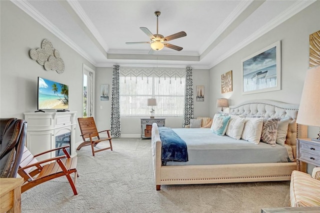 bedroom with a raised ceiling, a ceiling fan, crown molding, and carpet flooring